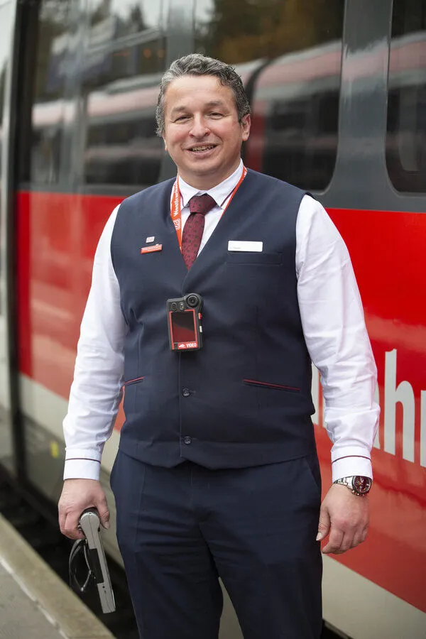 Glücklicher ÖPNV Mitarbeiter bei der Deutschen Bahn mit einer Body-Cam